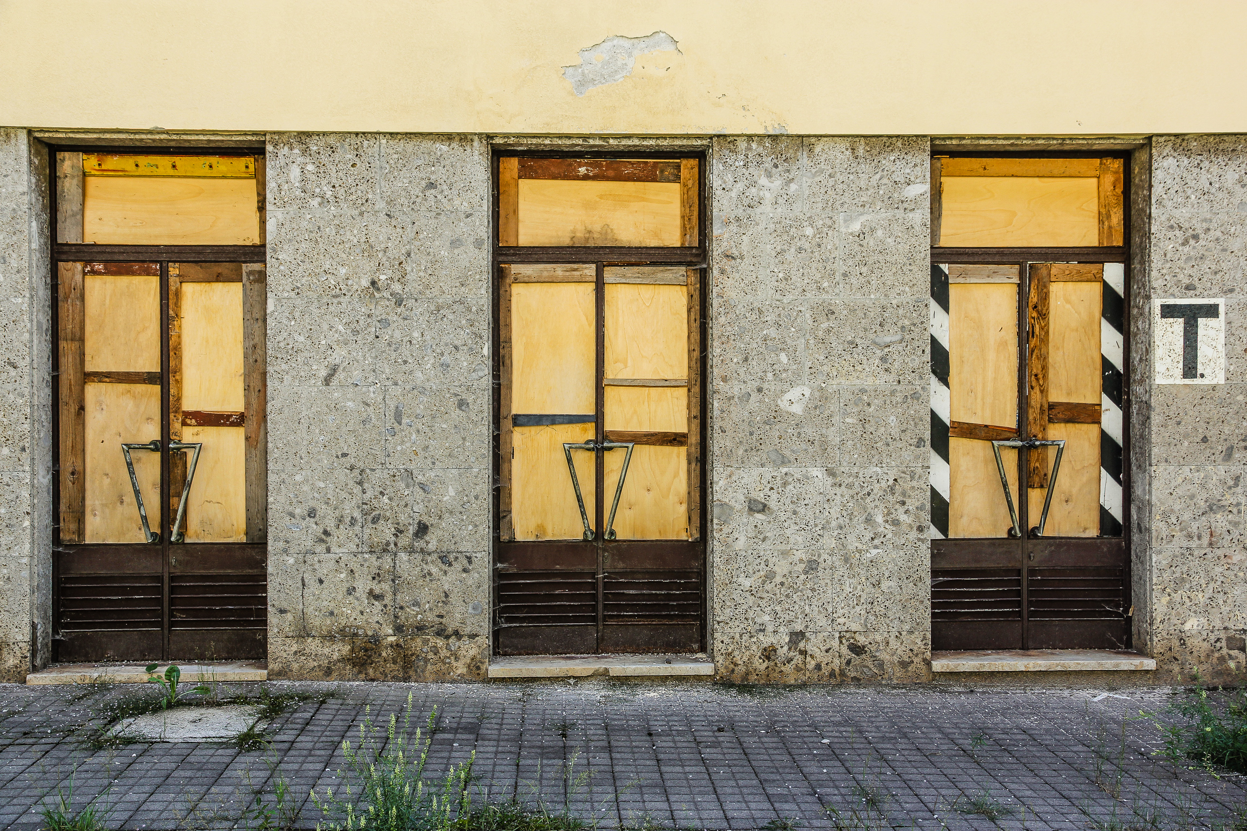 Mit Sperrholz verrammelte Schaufenster – aufgegebene Geschäfte am Weg